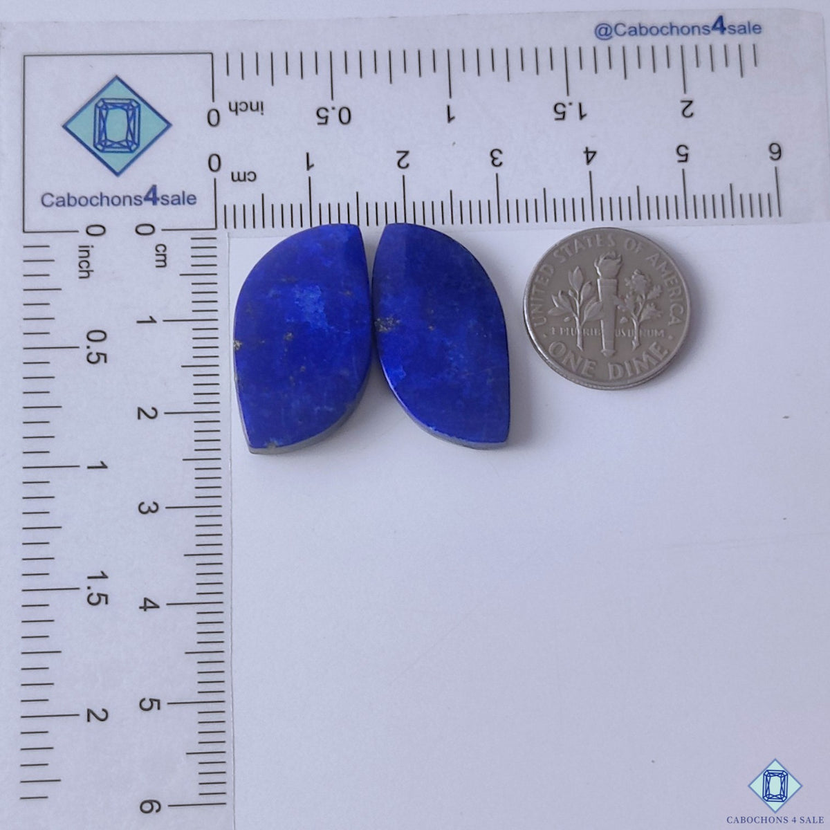 cabochons4sale, matching fancy lapis lazuli blue cabochon pairs featuring deep color, subtle natural patterns and distinctive gemstone character held between fingers