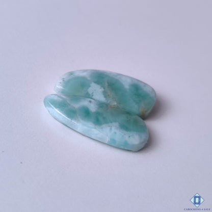 cabochons4sale, fancy blue and white larimar cabochons featuring tropical seascape-inspired markings, natural color variation and distinctive gemstone texture held between fingers