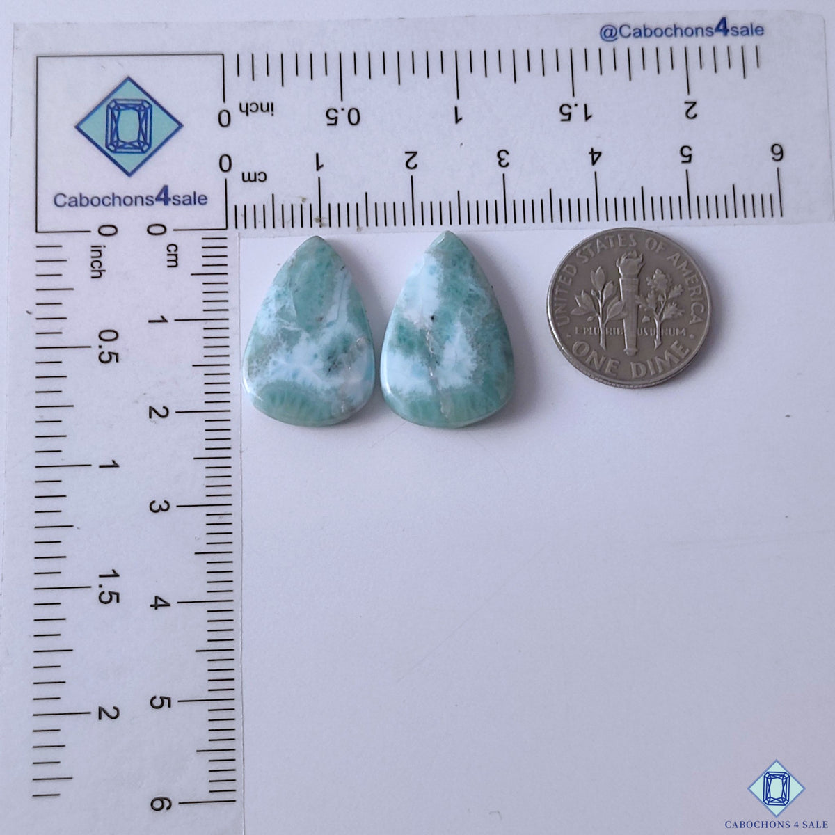 cabochons4sale, blue and white larimar pear gemstone cabochons showcasing cloudy mineral formations, flowing color zones and smooth polished stone texture held between fingers