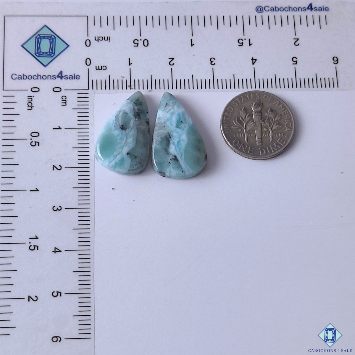 cabochons4sale, blue white larimar pear gemstone cabochons featuring cloud-like mineral patterns, Caribbean-inspired tones and smooth polished texture held between fingers