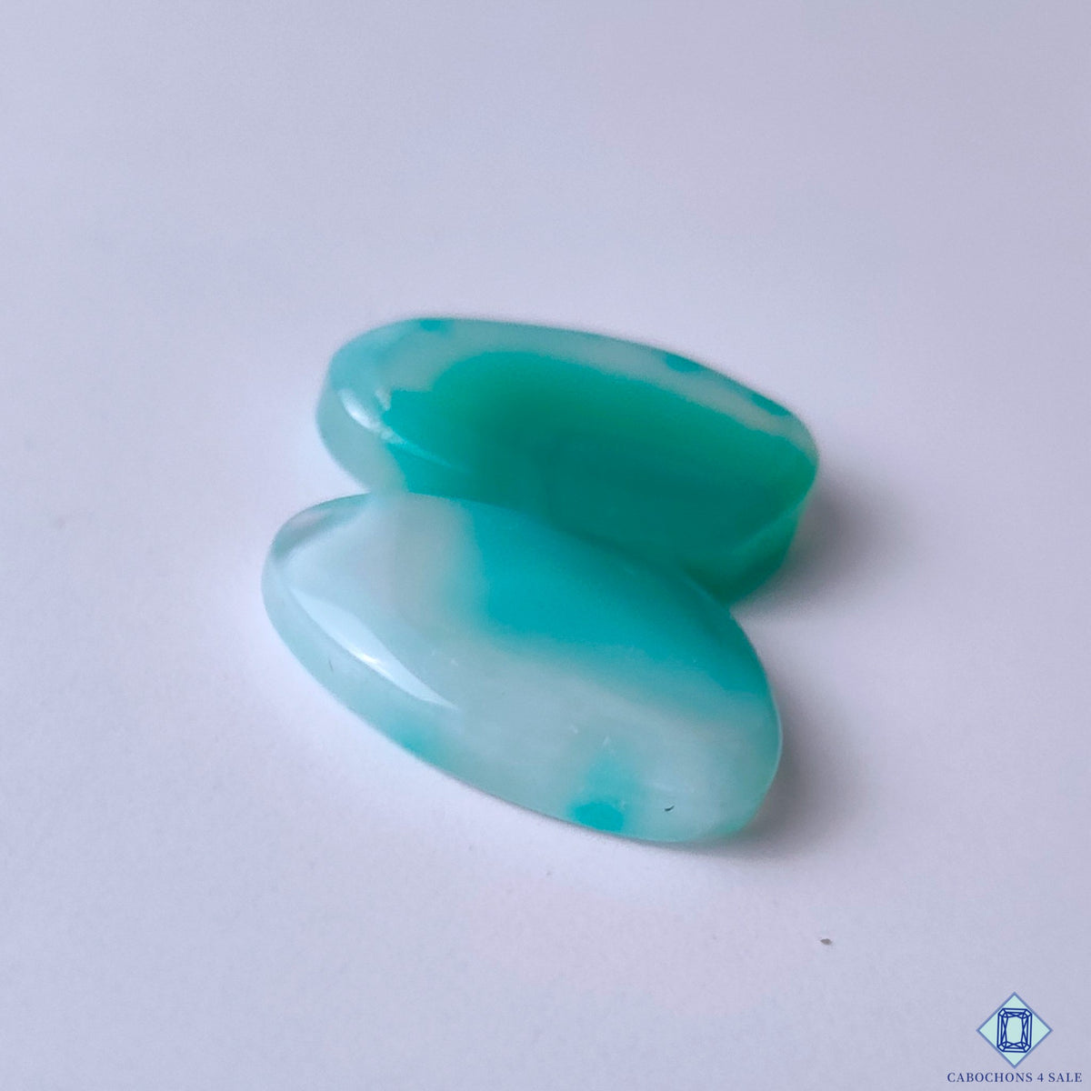 cabochons4sale, natural green banded agate fancy cabochons featuring contrasting white bands, flowing mineral designs and a refined polished gemstone finish held between fingers