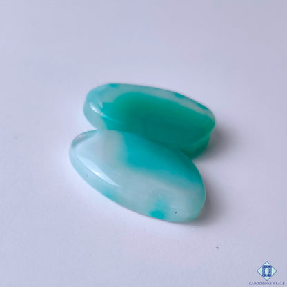 cabochons4sale, natural green banded agate fancy cabochons featuring contrasting white bands, flowing mineral designs and a refined polished gemstone finish held between fingers