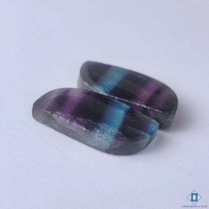 cabochons4sale, rainbow fluorite fancy cabochons showcasing vivid green, violet and blue hues with elegant mineral zoning and smooth gemstone polish held between fingers