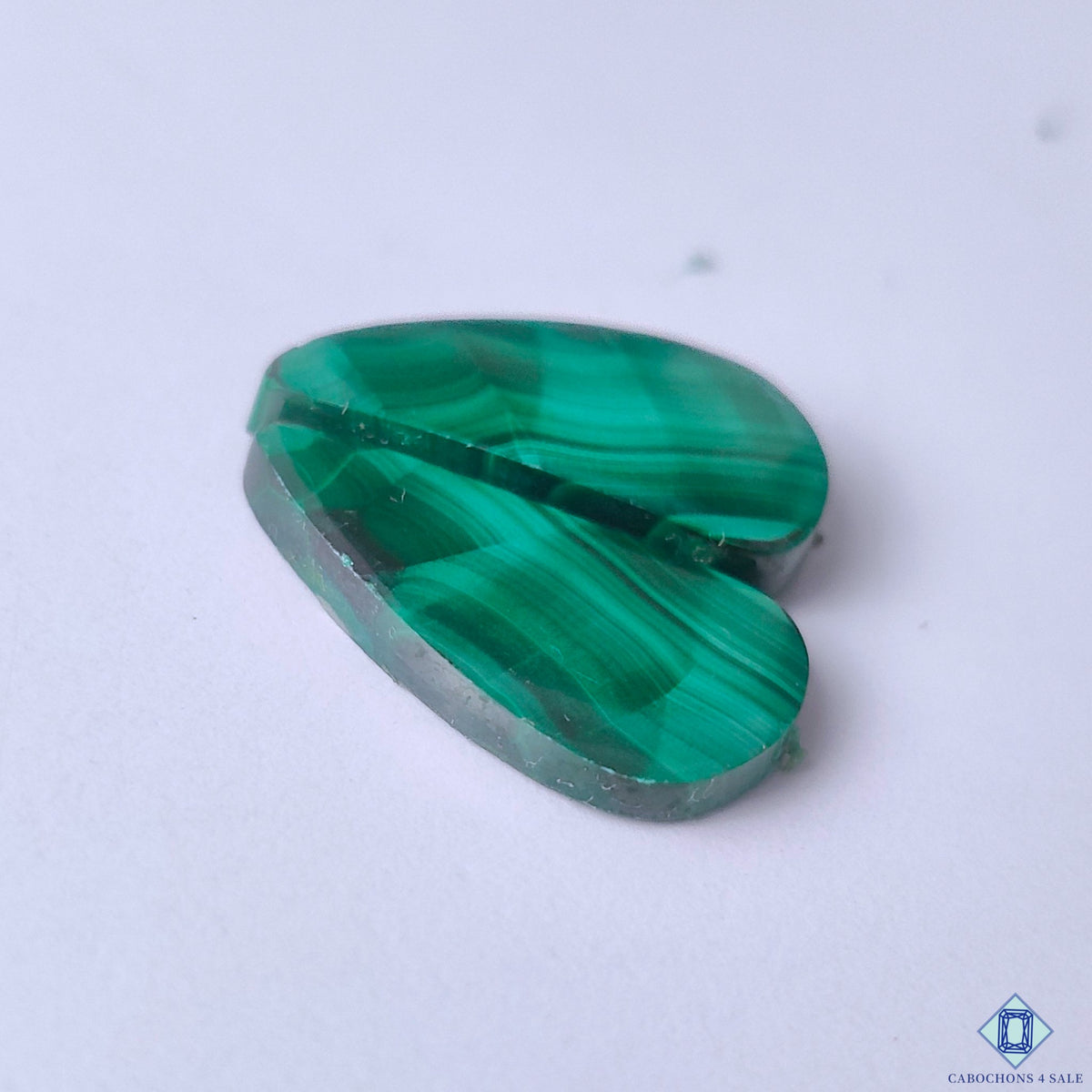 cabochons4sale, polished green malachite fancy cabochons featuring striking curved mineral layers, natural tonal variation and unique gemstone character held between fingers