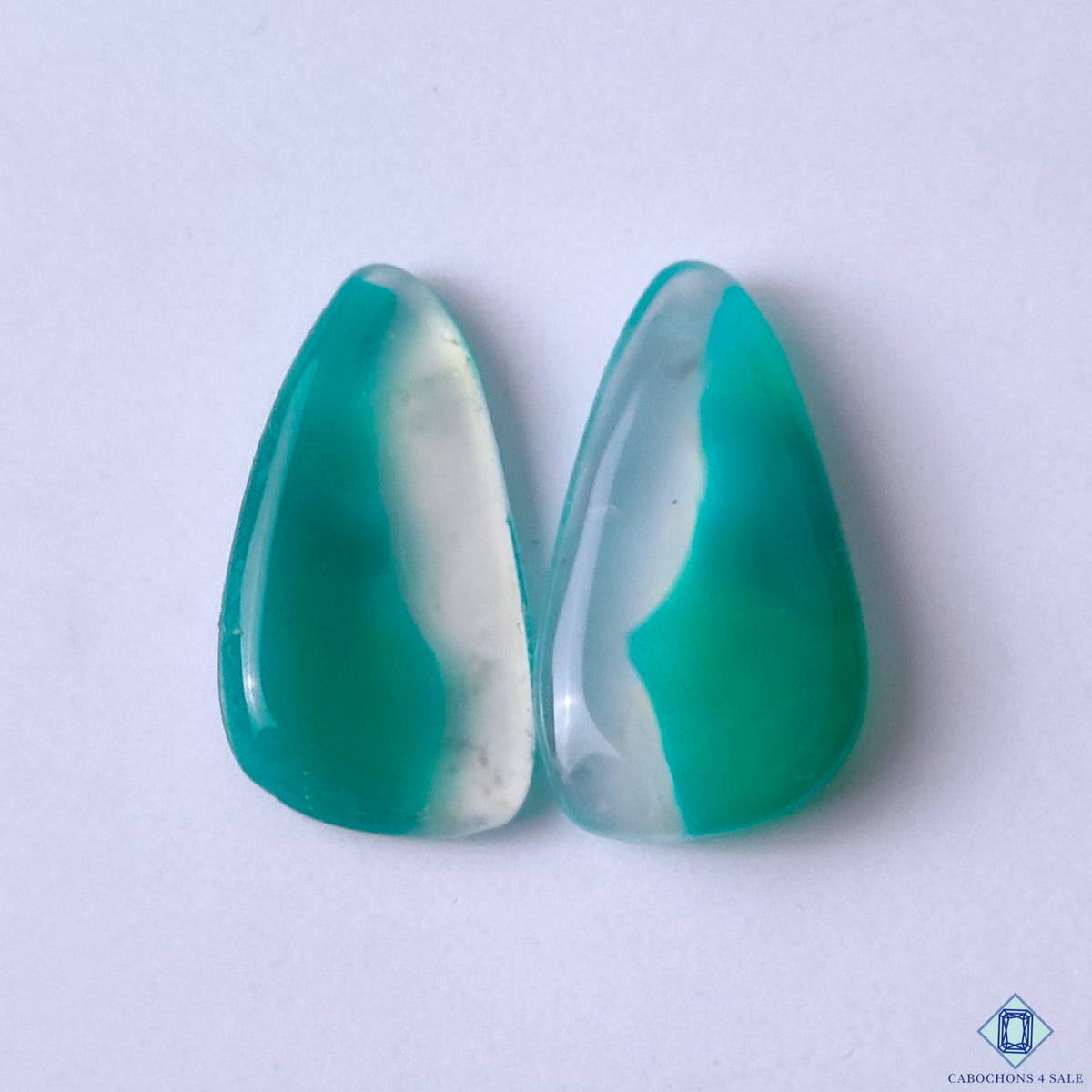 cabochons4sale, green banded agate fancy cabochons in green and white shades with flowing layered bands and natural mineral patterns held between fingers