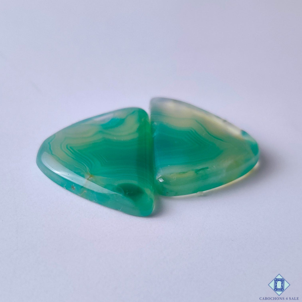 cabochons4sale, polished fancy green banded agate cabochons showcasing distinctive natural striping, organic mineral layers and elegant gemstone character held between fingers