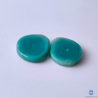 cabochons4sale, green banded agate oval cabochons showcasing delicate natural striping, rich green tones and distinctive mineral character held between fingers