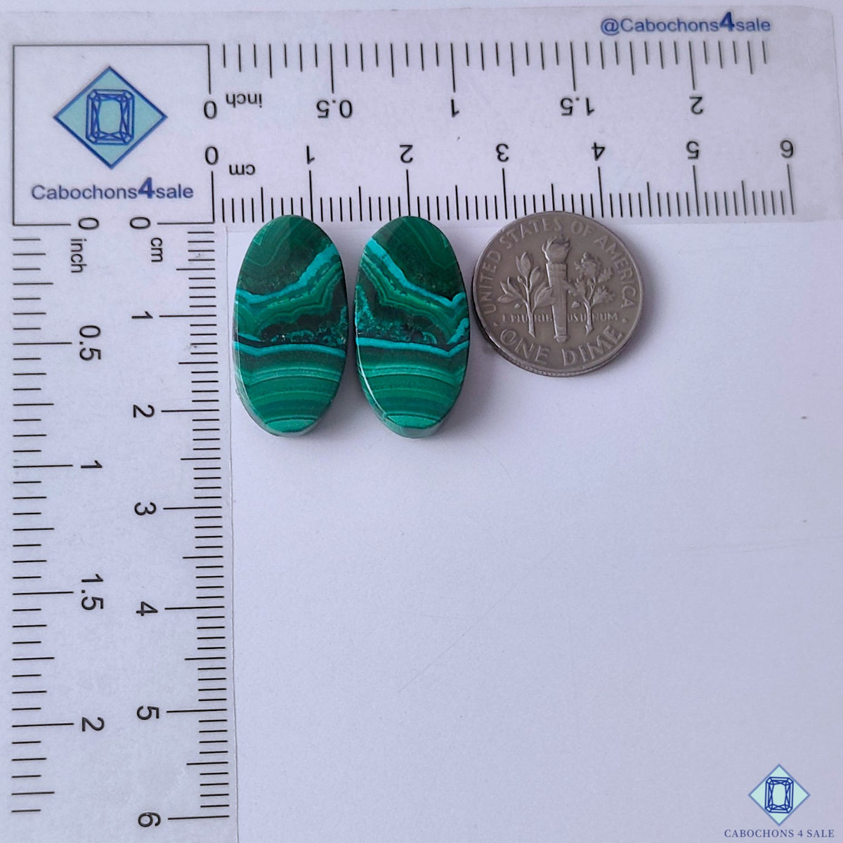 cabochons4sale, polished malachite oval gemstone cabochons in deep green shades with organic flowing patterns and smooth stone texture held between fingers