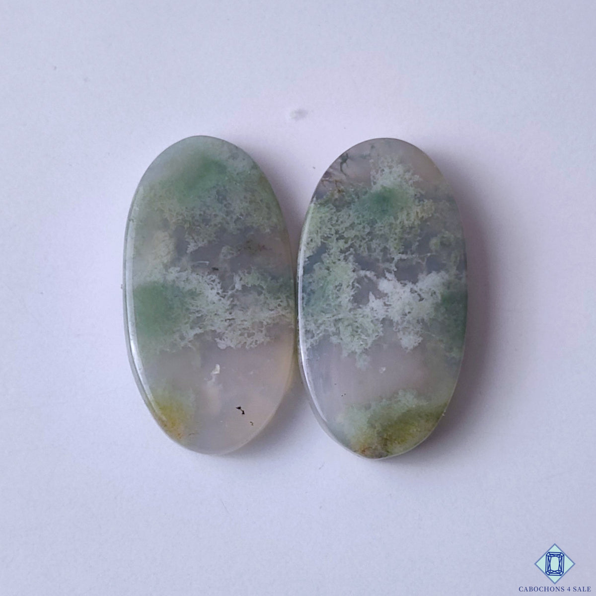 cabochons4sale, green moss agate oval cabochons with delicate garden-like inclusions and natural translucent stone patterns held between fingers