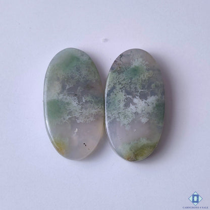 cabochons4sale, green moss agate oval cabochons with delicate garden-like inclusions and natural translucent stone patterns held between fingers