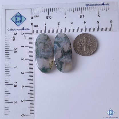 cabochons4sale, green moss agate oval gemstone cabochons displaying delicate botanical-style inclusions and polished natural stone surfaces held between fingers