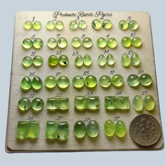 Cabochons4sale collection of polished mint green prehnite rutile quartz gemstones with golden needles on a display tray