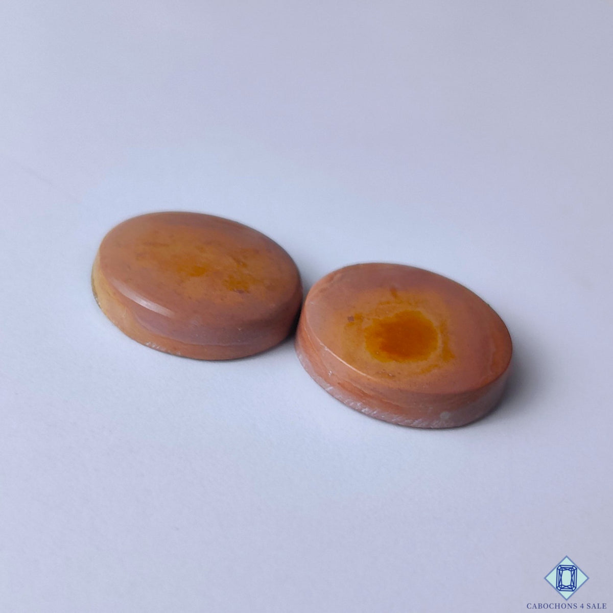 cabochons4sale, earthy brown imperial round cabochons showcasing distinctive mineral character, natural patterning and a glossy gemstone finish held between fingers