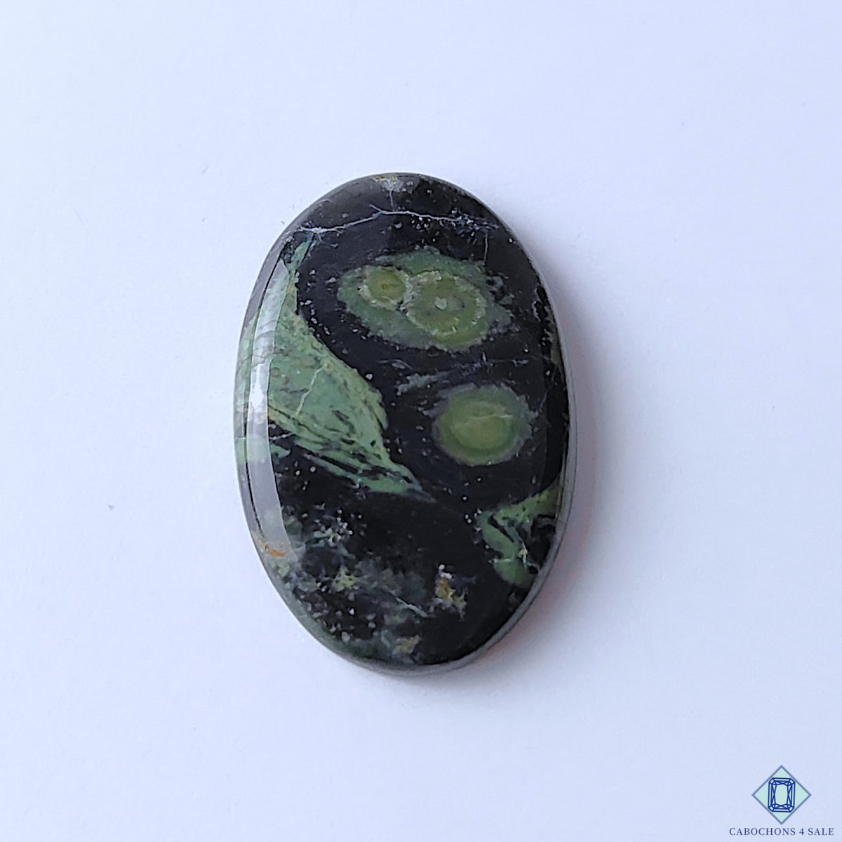 cabochons4sale, natural Kambaba Jasper oval cabochons in green and black tones with distinctive orbicular patterns and polished gemstone surfaces held between fingers