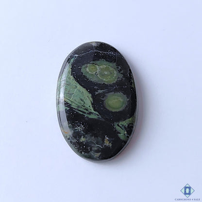 cabochons4sale, natural Kambaba Jasper oval cabochons in green and black tones with distinctive orbicular patterns and polished gemstone surfaces held between fingers