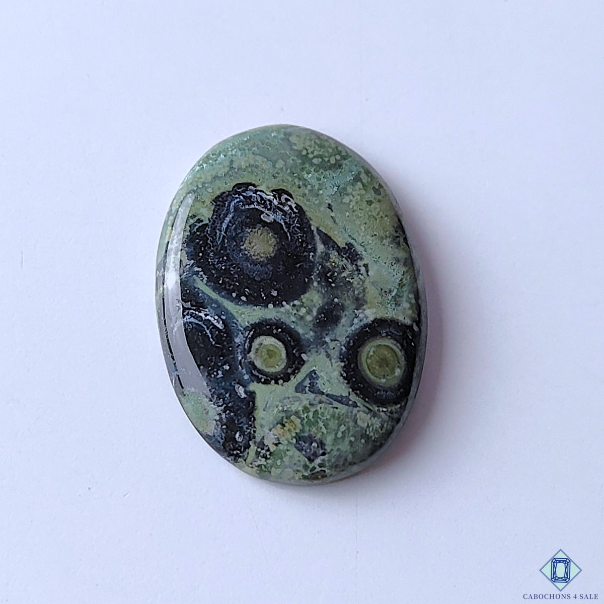 cabochons4sale, Kambaba Jasper oval cabochons in deep green and black shades with rounded natural patterns, earthy mineral texture and polished finish held between fingers