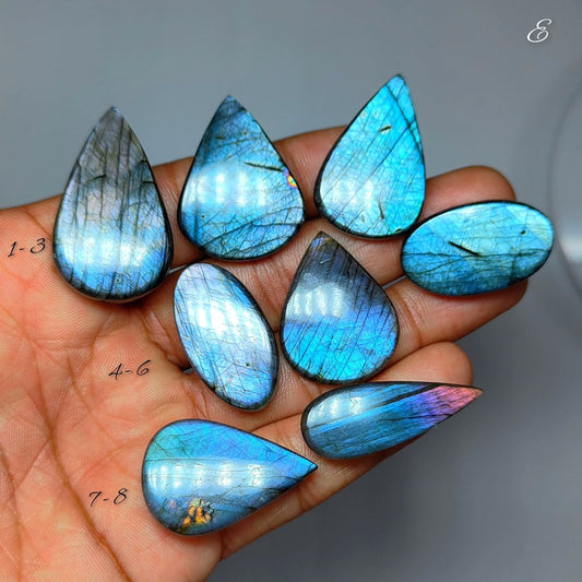 Cabochons4sale natural labradorite gemstones with vibrant blue and violet flashes held in a hand for scale.