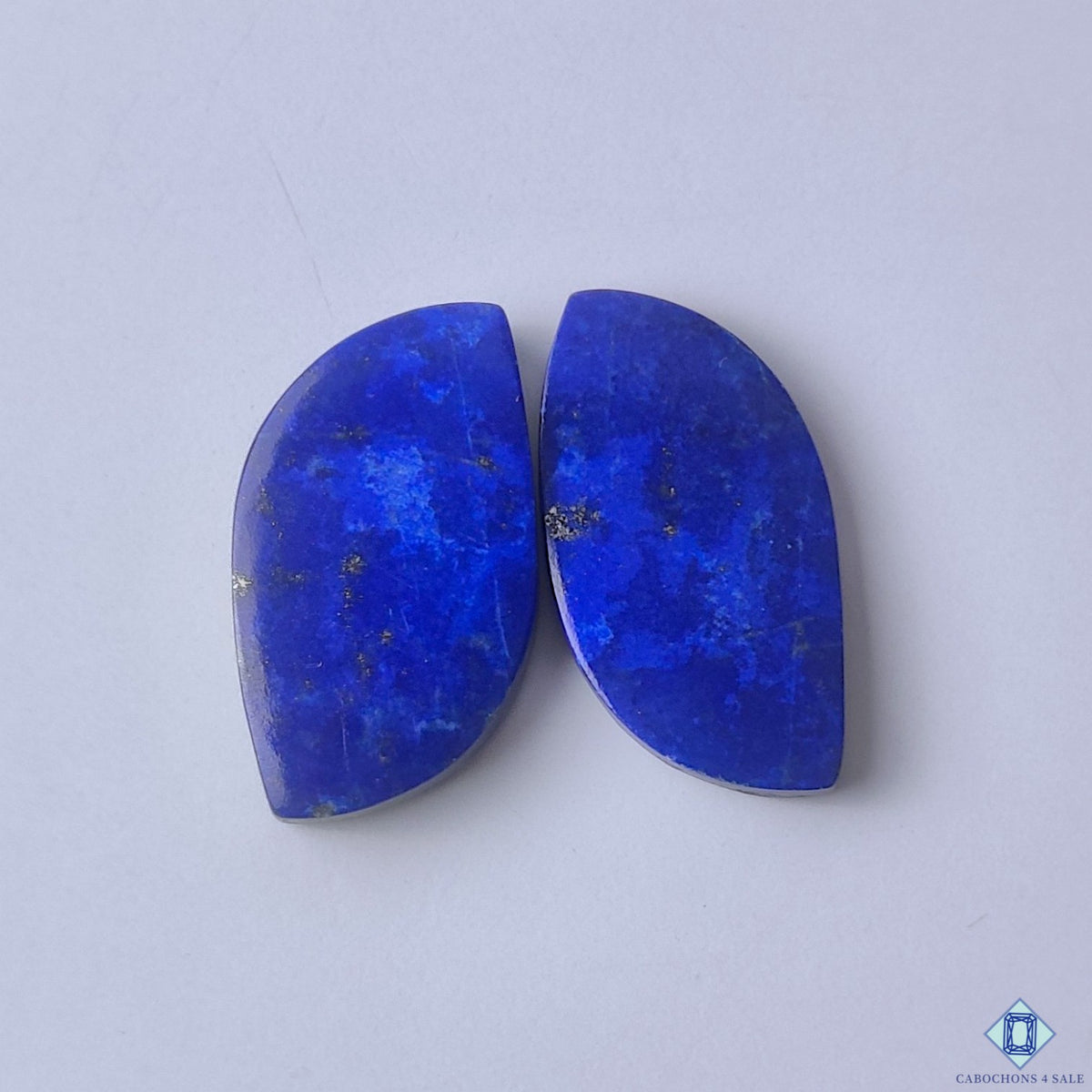 cabochons4sale, fancy blue lapis lazuli pairs with rich royal tones, natural mineral texture and polished cabochon surfaces held between fingers
