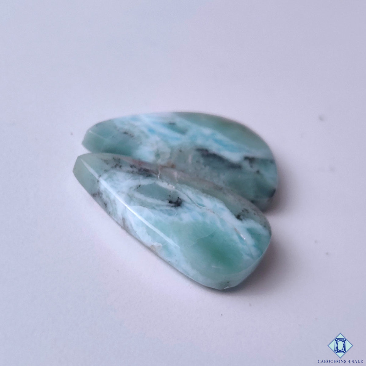 cabochons4sale, ocean blue larimar pear cabochons accented with natural white mineral formations, flowing patterns and distinctive stone character held between fingers