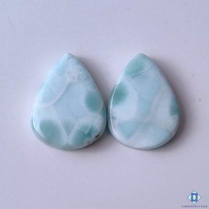 cabochons4sale, aqua blue and white larimar pear cabochons with natural wave-like patterns, soft cloud formations and polished gemstone finish held between fingers
