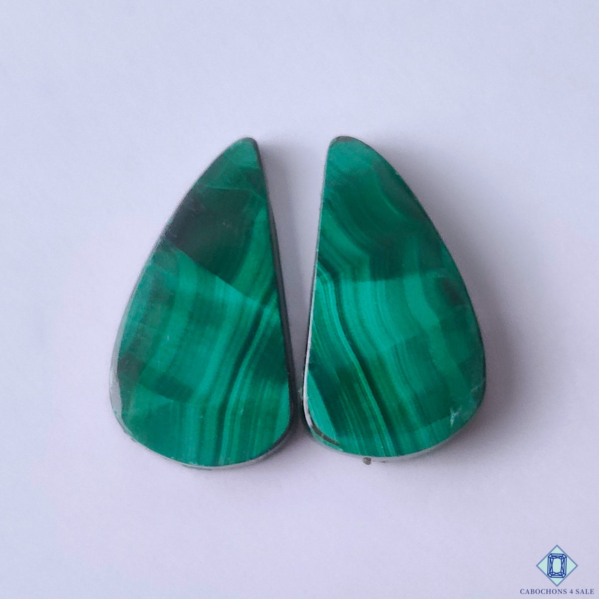 cabochons4sale, natural green malachite fancy cabochons with distinctive concentric banding, rich mineral patterns and polished gemstone surfaces held between fingers