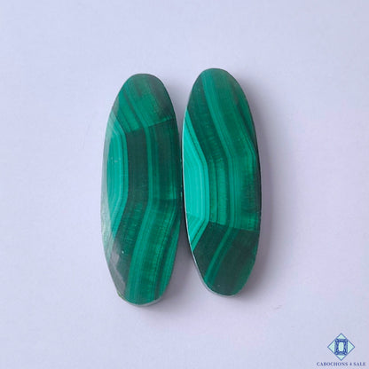 cabochons4sale, natural green malachite oval cabochons with distinctive concentric banding and rich mineral patterns held between fingers