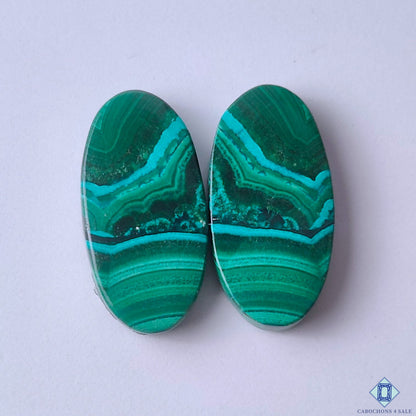 cabochons4sale, rich green malachite oval cabochons with layered concentric bands and natural mineral depth held between fingers