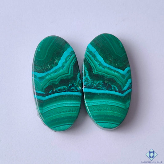 cabochons4sale, rich green malachite oval cabochons with layered concentric bands and natural mineral depth held between fingers