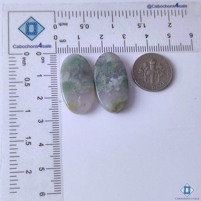 cabochons4sale, polished moss agate oval gemstone cabochons in soft green shades with branching mineral formations and earthy visual texture held between fingers