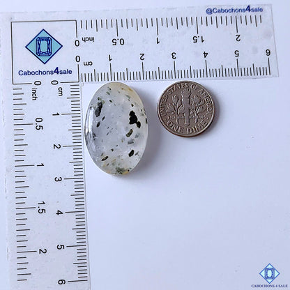 cabochons4sale, natural black dot quartz oval cabochons featuring scattered black spots across a light quartz base, distinctive inclusion details and smooth gemstone texture held between fingers