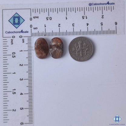 cabochons4sale, natural purple haze sunstone oval cabochons featuring soft violet color, delicate aventurescent sparkle and polished stone texture held between fingers
