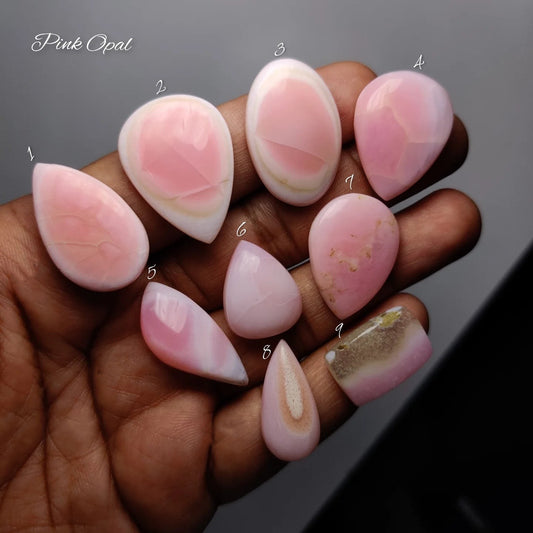 Cabochons4sale natural pink opal gemstones in various shapes and blush tones held in a hand for jewelry making