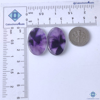 cabochons4sale, purple chevron amethyst oval gemstone cabochons featuring layered white quartz bands, rich violet tones and smooth polished texture held between fingers