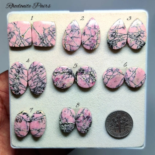Cabochons4sale natural rhodonite gemstone pairs in various shapes with rosy pink colour and black matrix patterns.