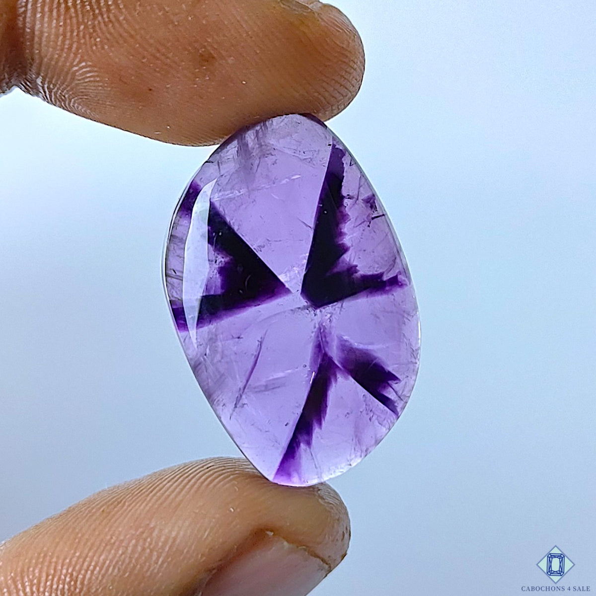 cabochons4sale, trapiche amethyst fancy cabochons in rich purple tones with distinctive radial zoning, natural crystal formations and polished surfaces held between fingers