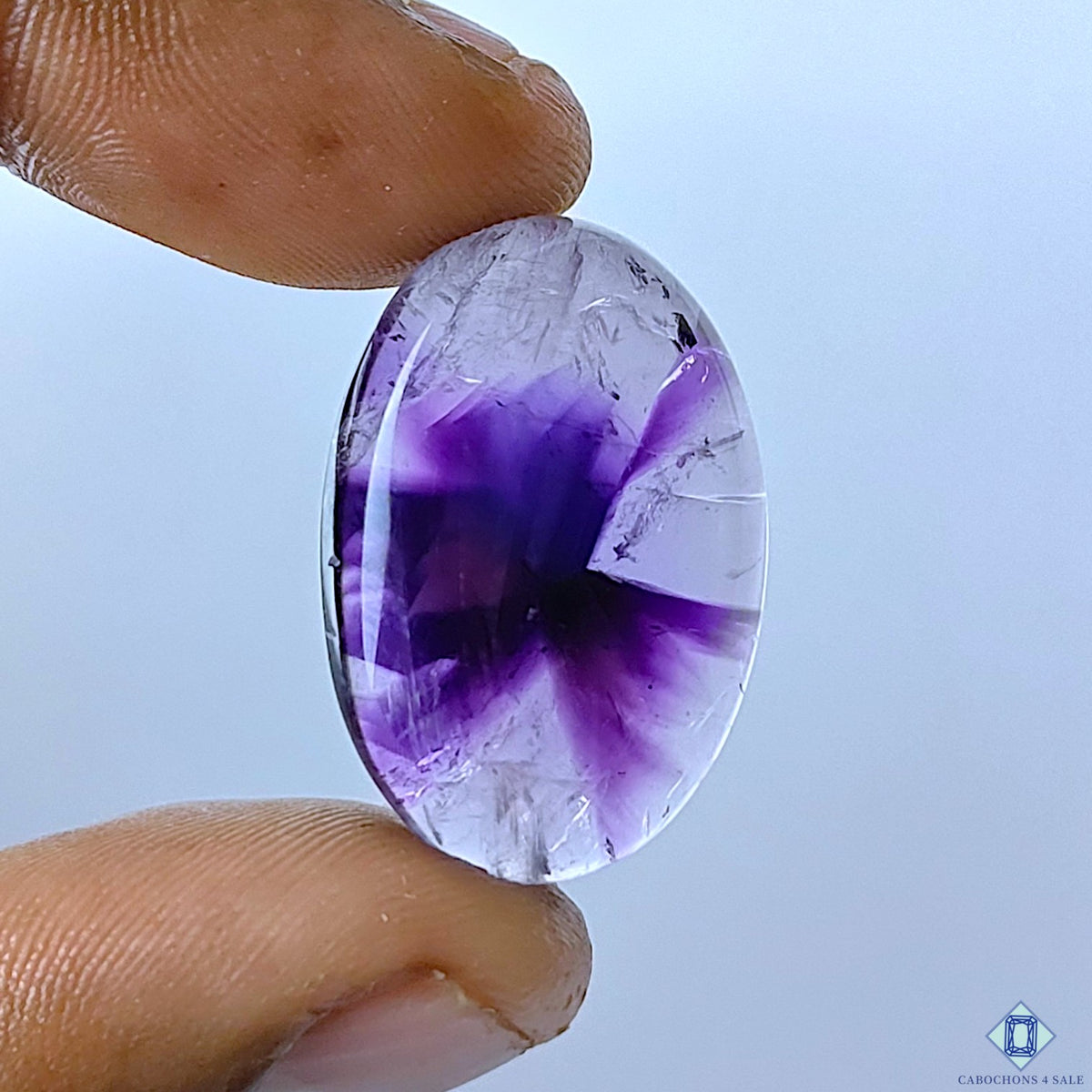 cabochons4sale, natural trapiche amethyst oval cabochons in rich purple tones with distinctive radial zoning, crystalline patterns and polished surfaces held between fingers