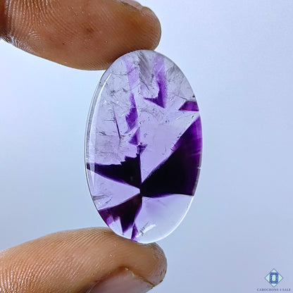 cabochons4sale, trapiche amethyst oval cabochons in deep purple shades with striking radial patterns, natural crystal zoning and a smooth polished finish held between fingers