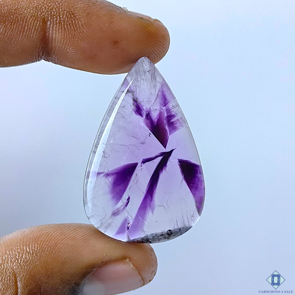 cabochons4sale, natural trapiche amethyst pear cabochons in rich purple tones with distinctive geometric zoning, crystalline patterns and polished surfaces held between fingers