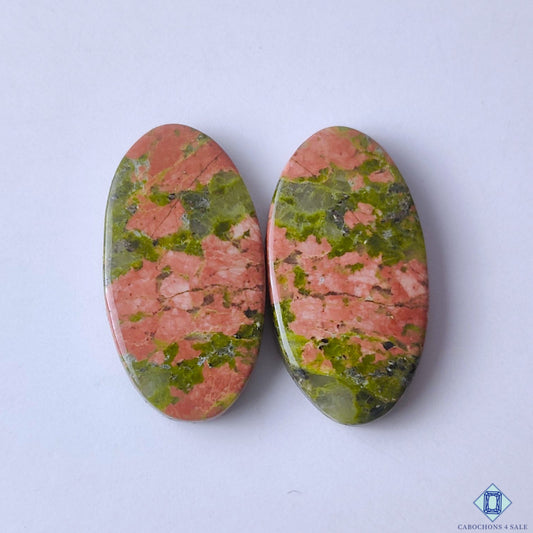 cabochons4sale, natural green and orange unakite oval cabochons with mottled mineral patterns and polished gemstone surfaces held between fingers